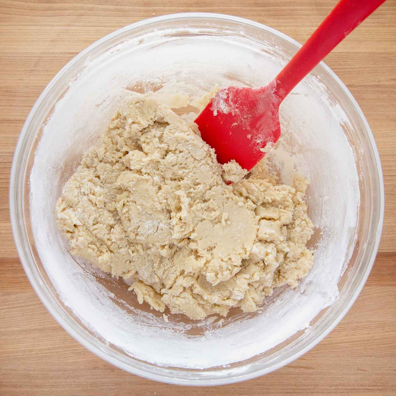 biscotti dough in a glass bowl with a red spatula