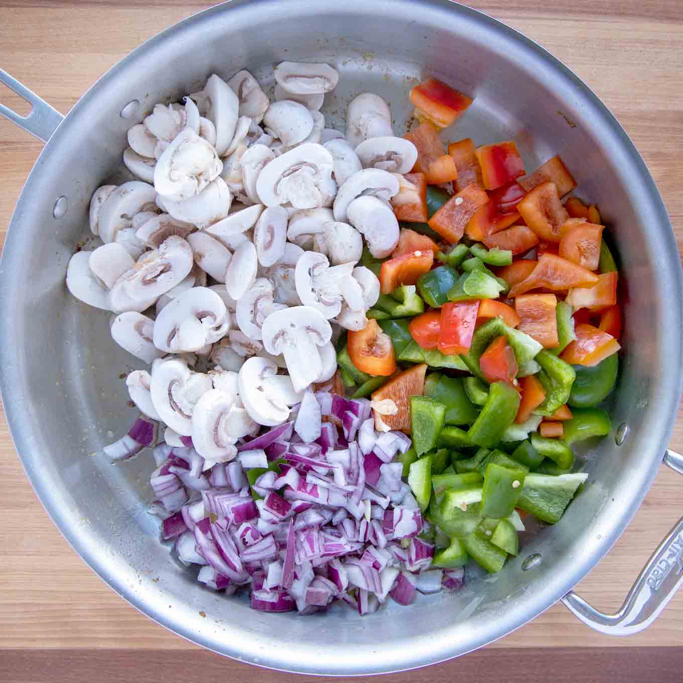 raw peppers, onions and mushrooms in a large skillet