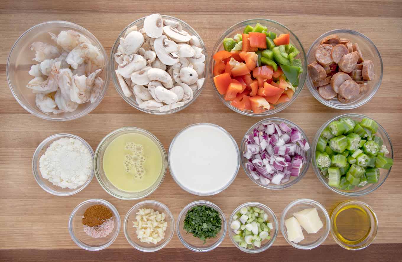ingredients to make shrimp and sausage in glass bowls