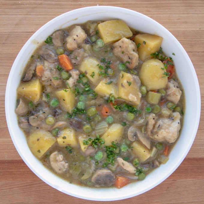 rustic chicken stew in a white bowl