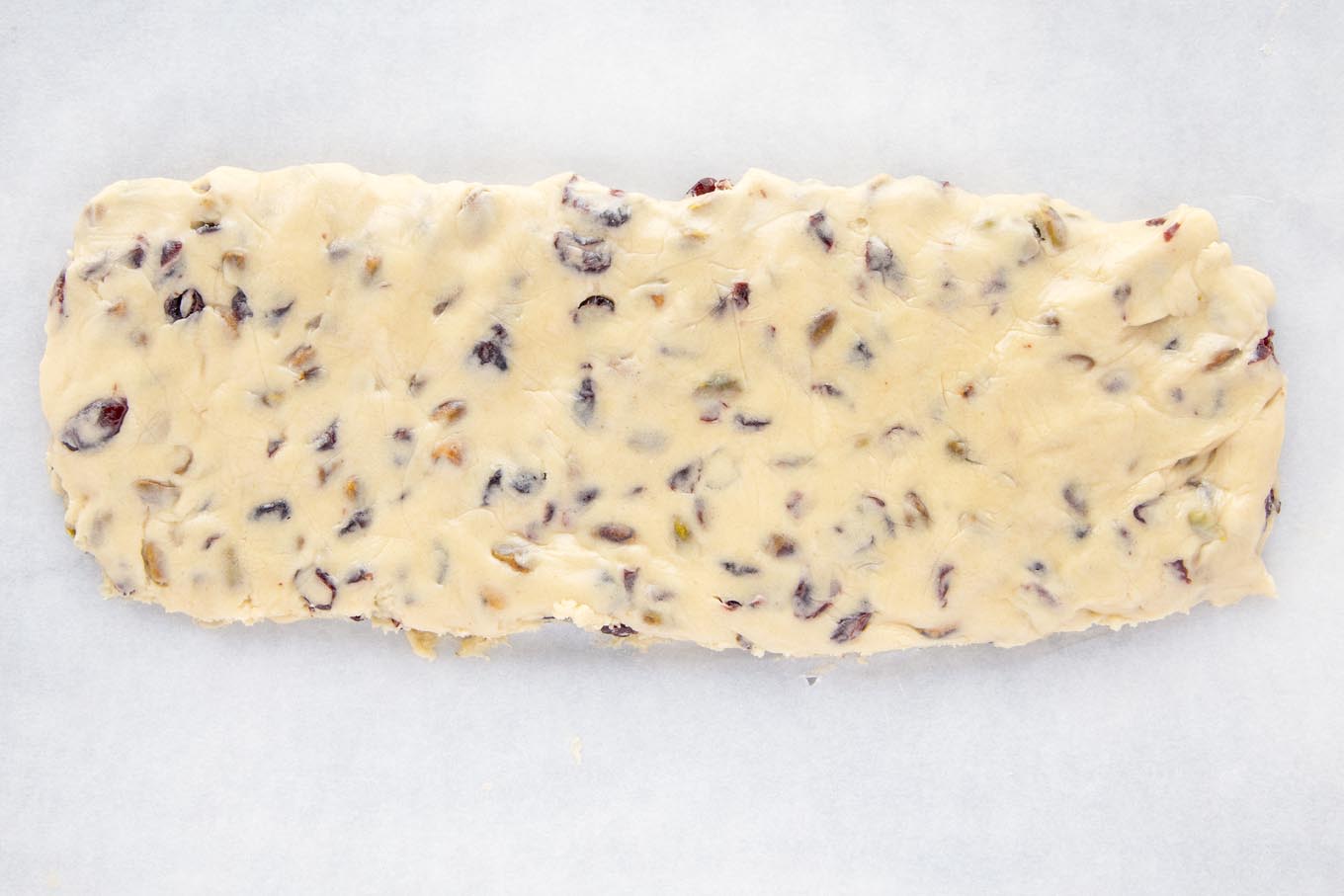 unbaked biscotti log on parchment paper