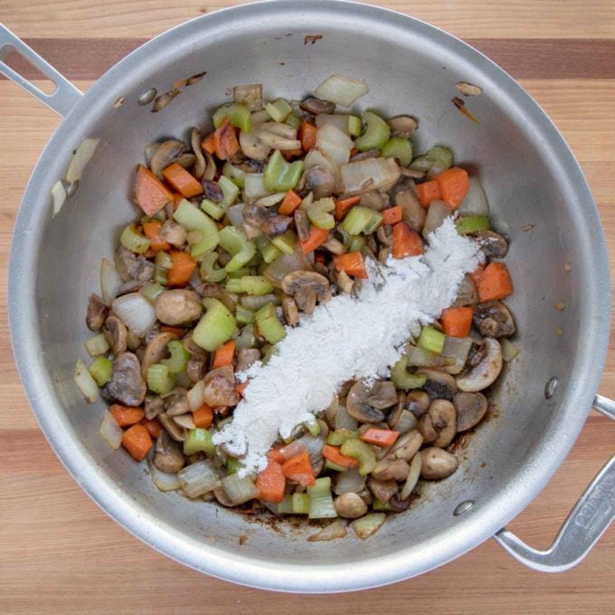 sautéed vegetables in a pan with flour added to make the roux.