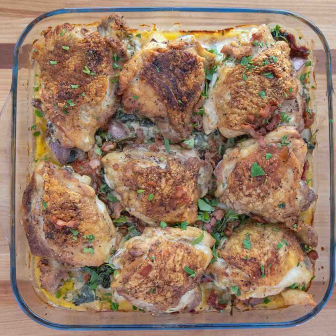 finished tuscan chicken sprinkled with parsley and bacon in the baking dish