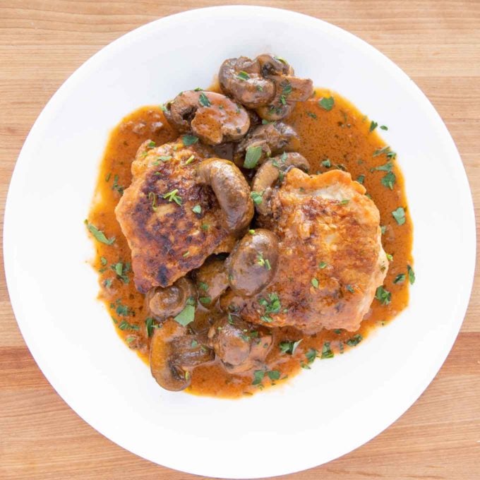 overhead shot of chicken chasseur on a white plate