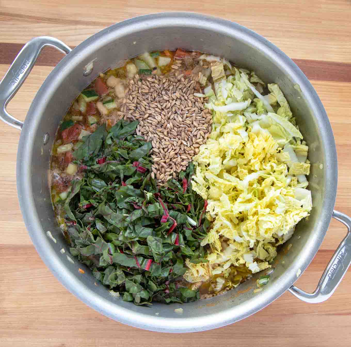 greens and farro added to pot