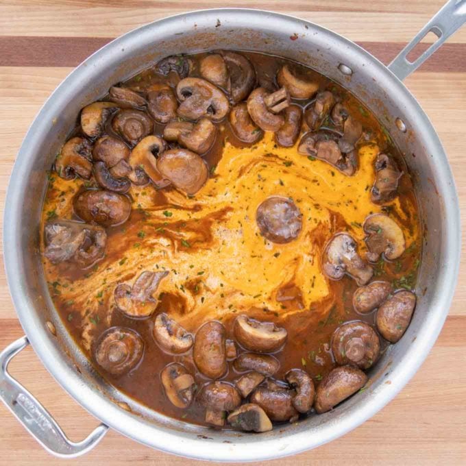 Cream added to the mushroom sauce in the skillet