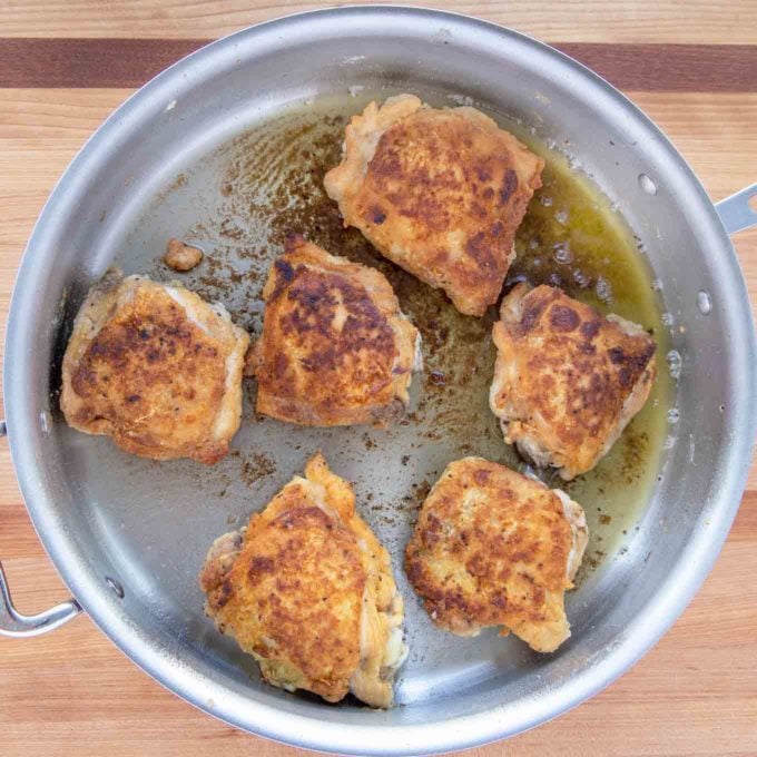 browned chicken thighs in a large skillet