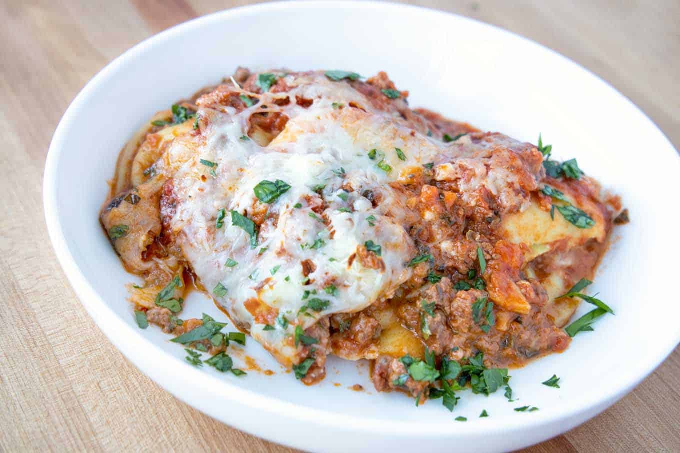 ravioli lasagna with plant based bolognese in white bowl