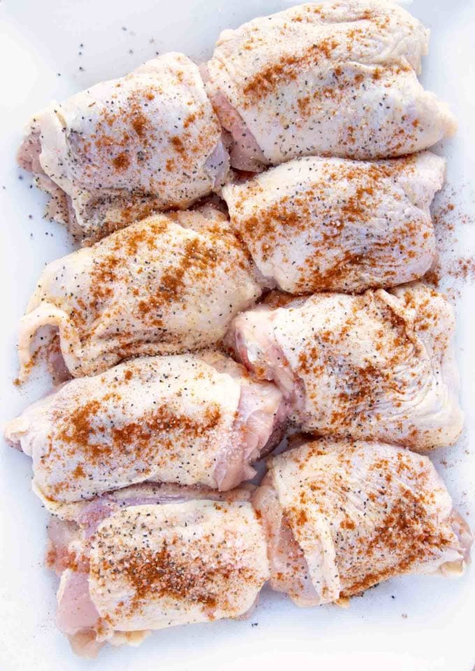 seasoned chicken thighs on a white platter