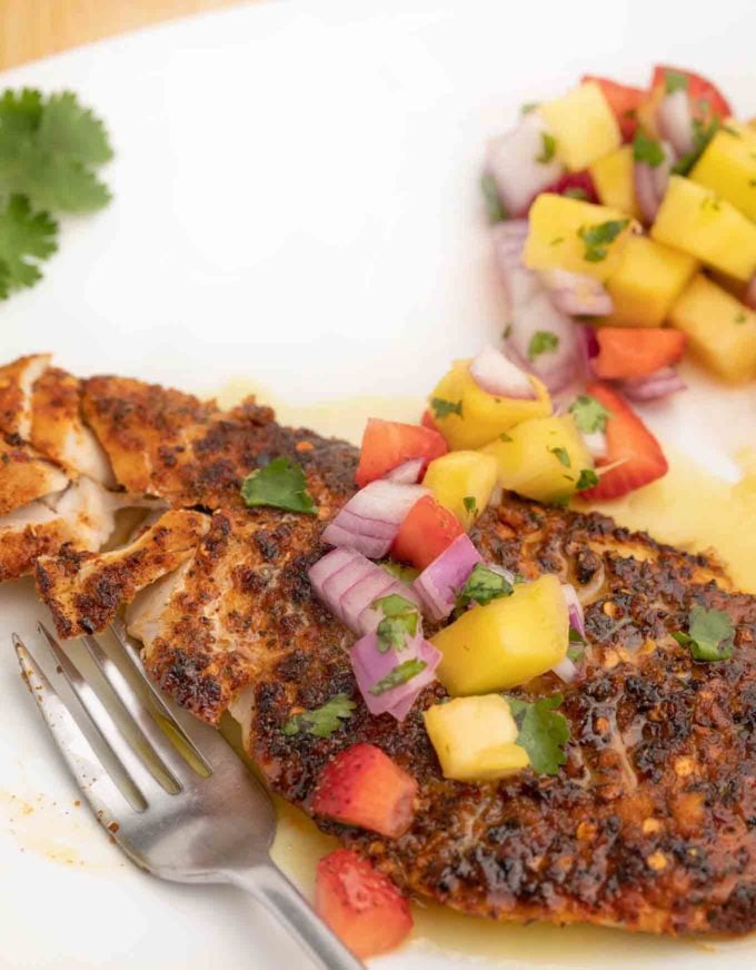 Blackened Snapper  with fruit salsa on white plate.