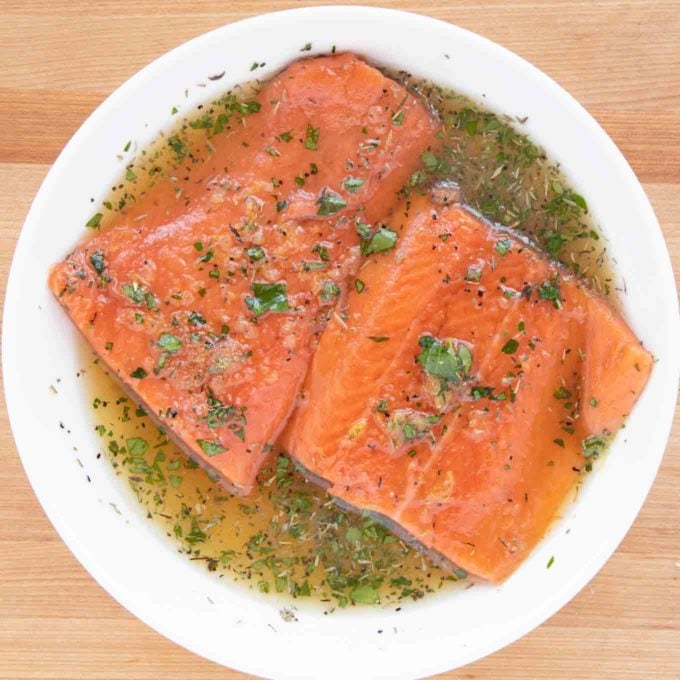 salmon marinating in a white deep bowl