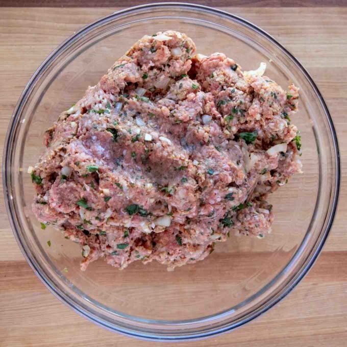 ingredients for meatloaf all mixed together in a glass bowl