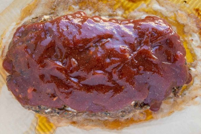 baked meatloaf topped with glaze on a baking sheet