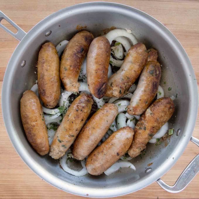 sausages added back into the pan on top of the onions