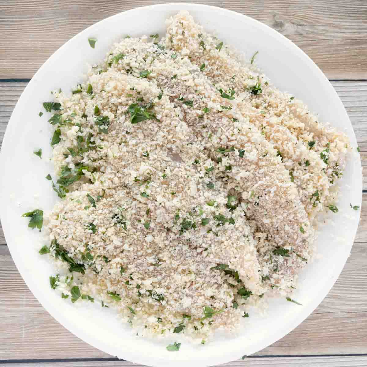 breaded flounder fillets on a white platter