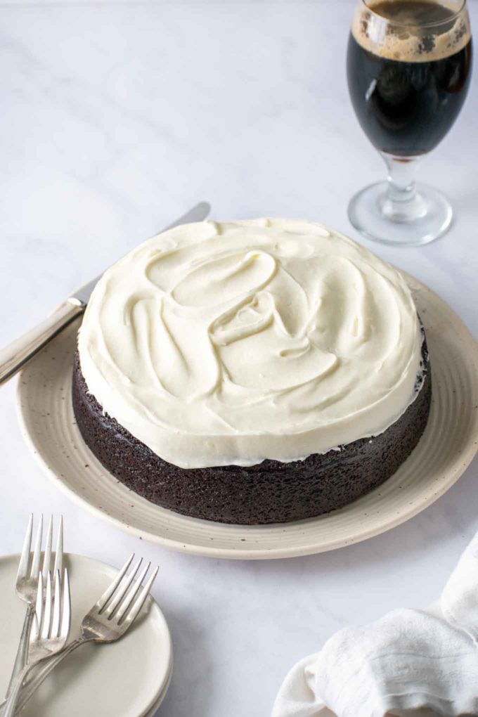 whole frosted guinness chocolate cake with a pint of guinness in the back ground