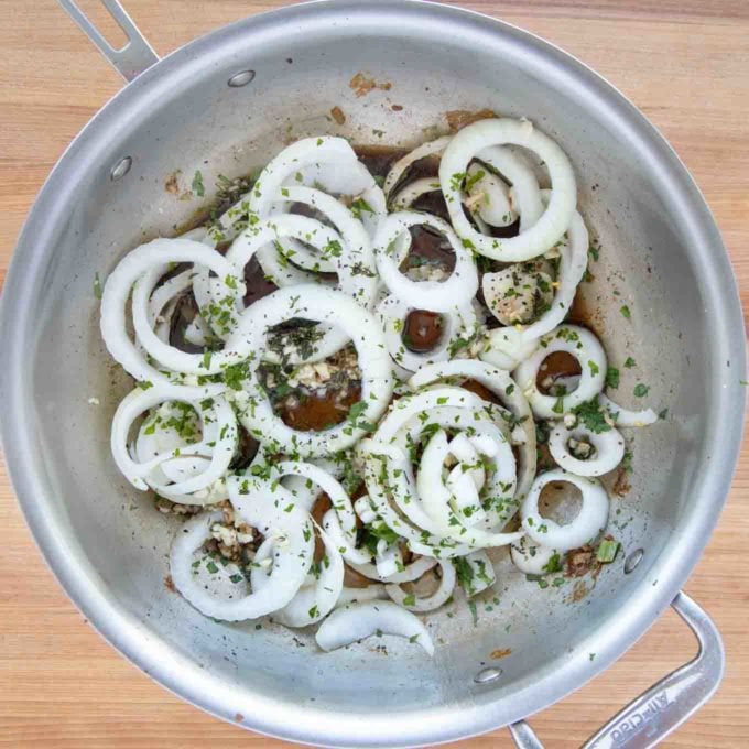 sliced onions added to the skillet, seasoned with salt, pepper, thyme and parsley