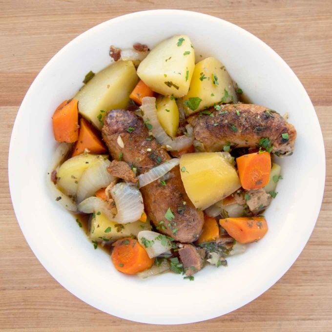 overhead shot of Dublin Coddle made with chicken sausages in a white bowl.