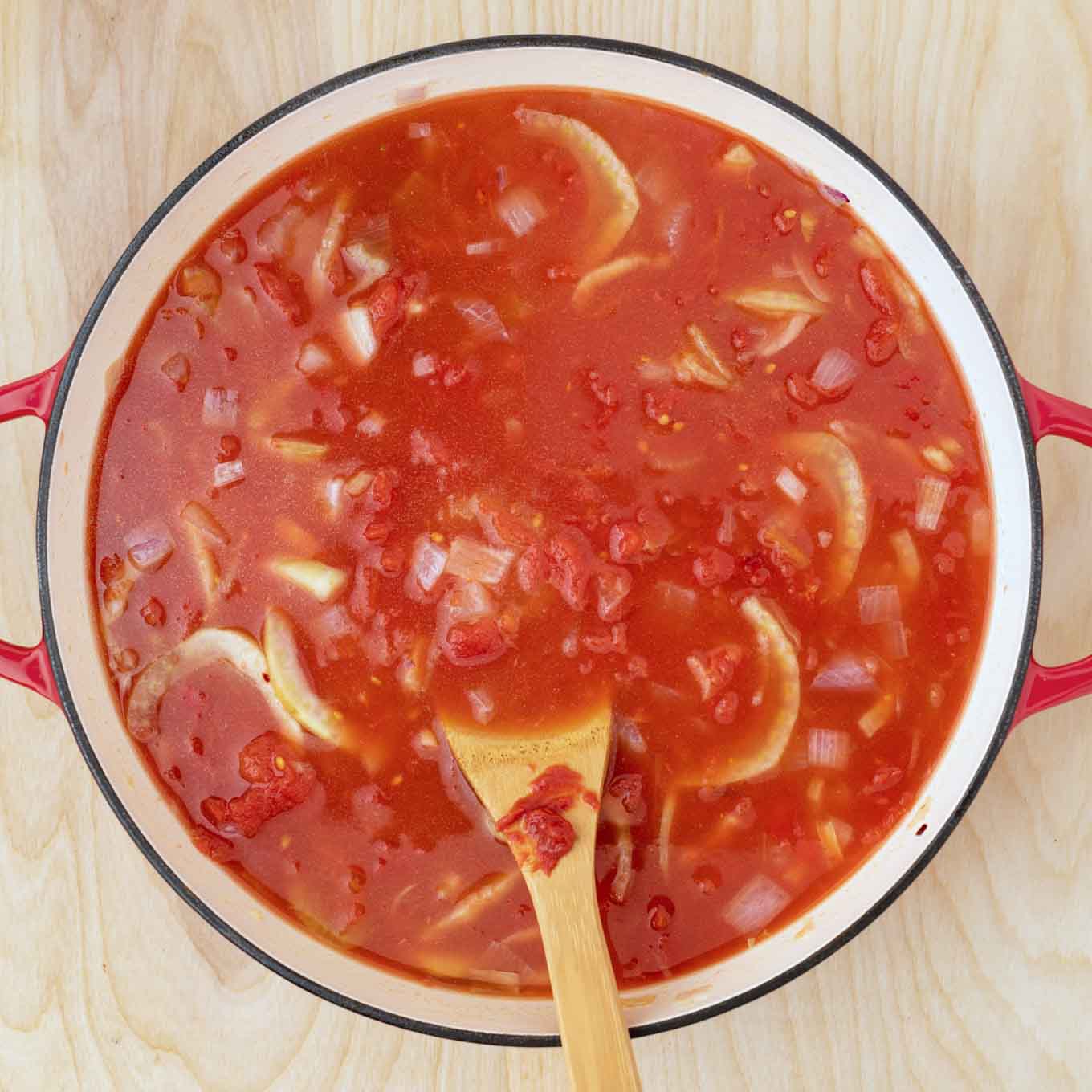 tomatoes, wine and stock added to the pot to make the cioppino sauce