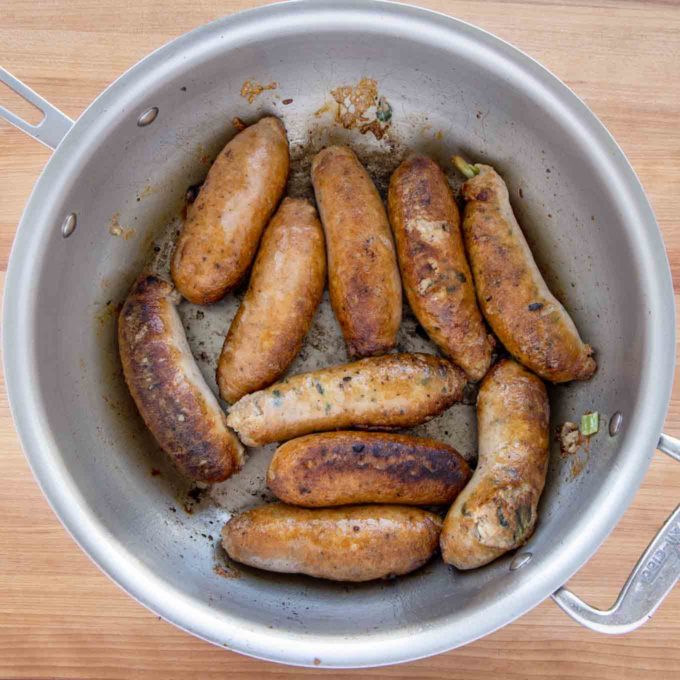 seared chicken sausages in a large skillet