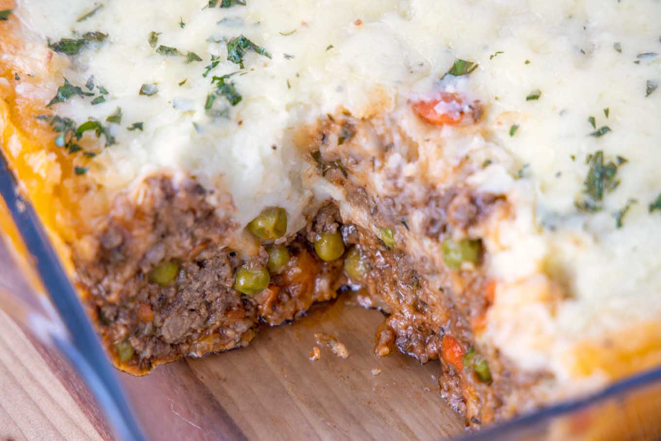 Cooked cottage pie with slice taken out.