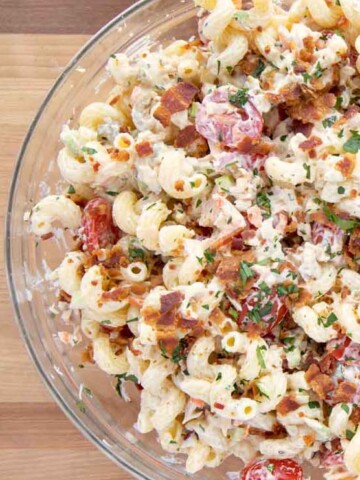 overhead partial view of bowl of Tuna Macaroni Salad Deluxe topped with crispy bacon bits and parsley