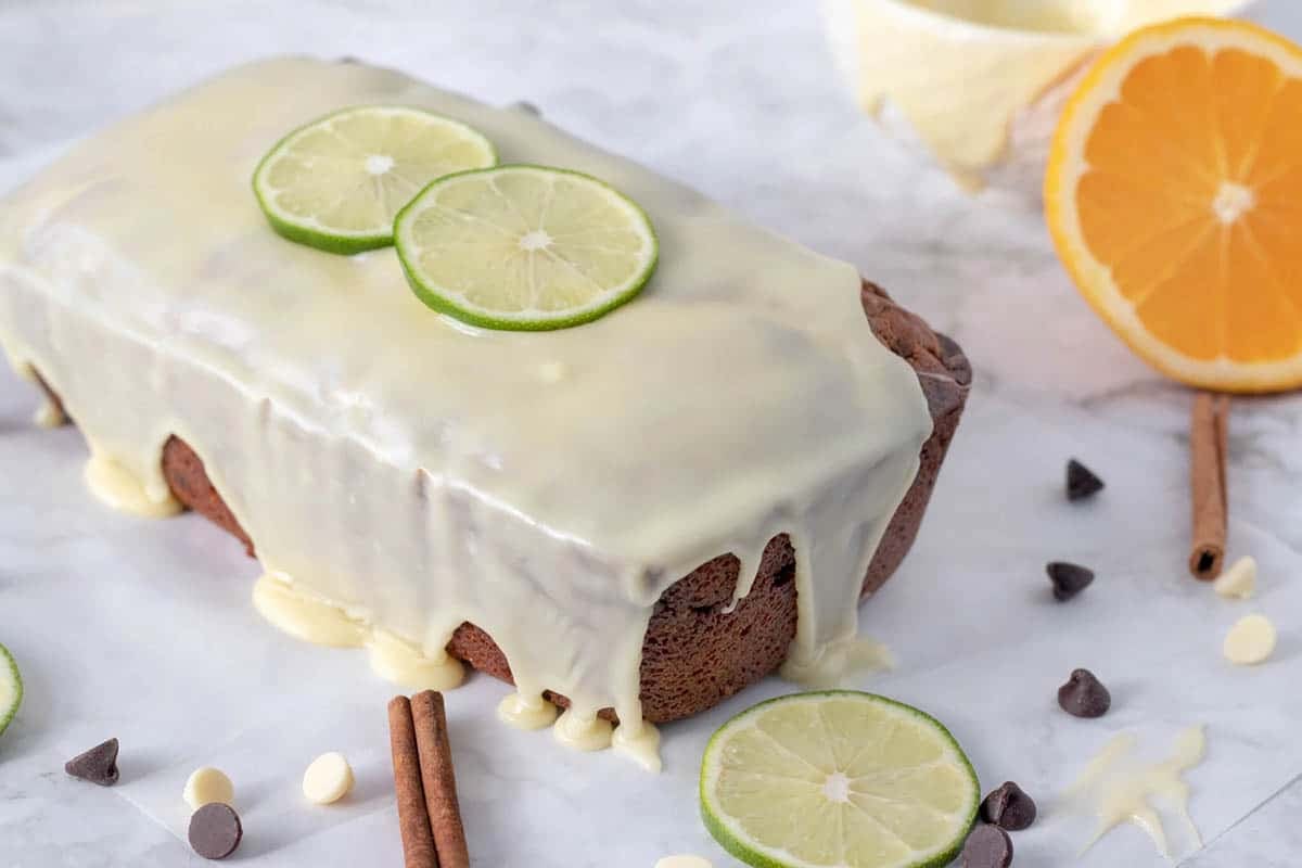 whole cannoli pound cake topped with glaze on a white plate