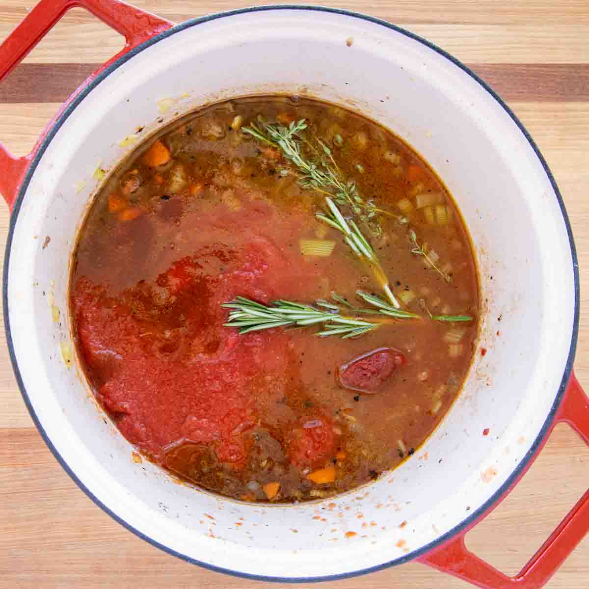 tomatoes, stock and seasonings added to the pot