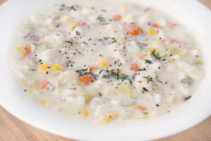 close up of fish chowder in white bowl