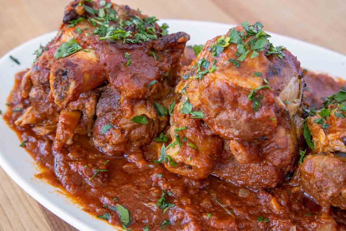 close up of pork osso bucco on a white platter