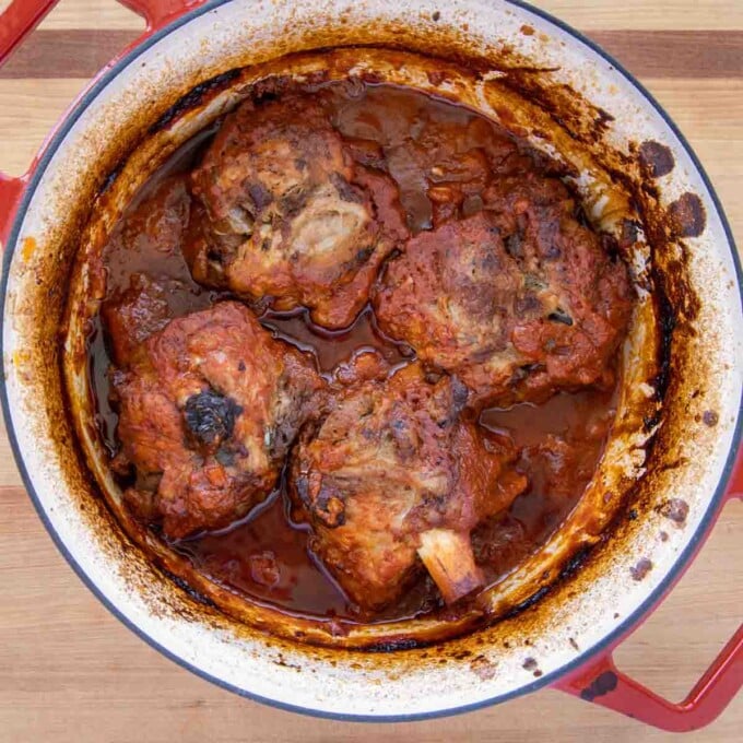 fully cooked pork shanks in pot of tomato sauce