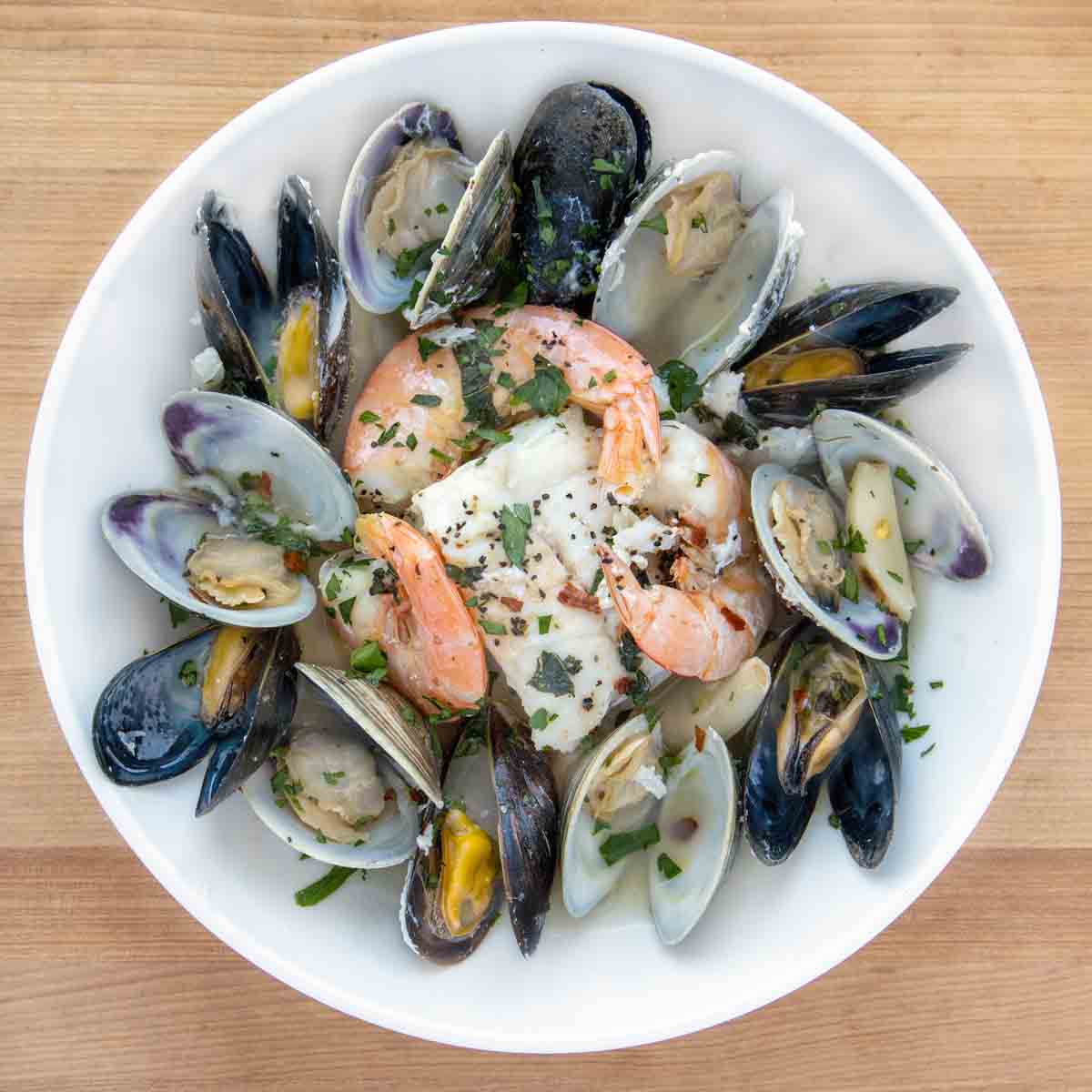 overhead view of seafood combo in a white bowl.