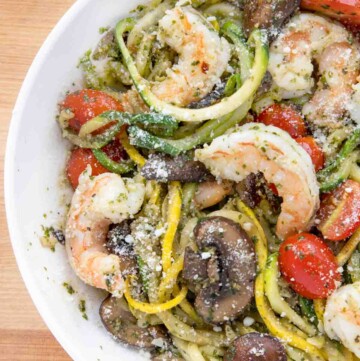 Partial overhead view of shrimp and zoodles in a white bowl