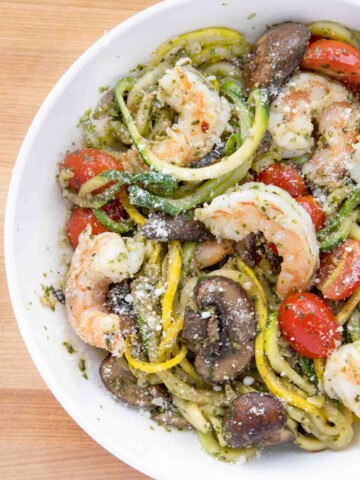 Partial overhead view of shrimp and zoodles in a white bowl