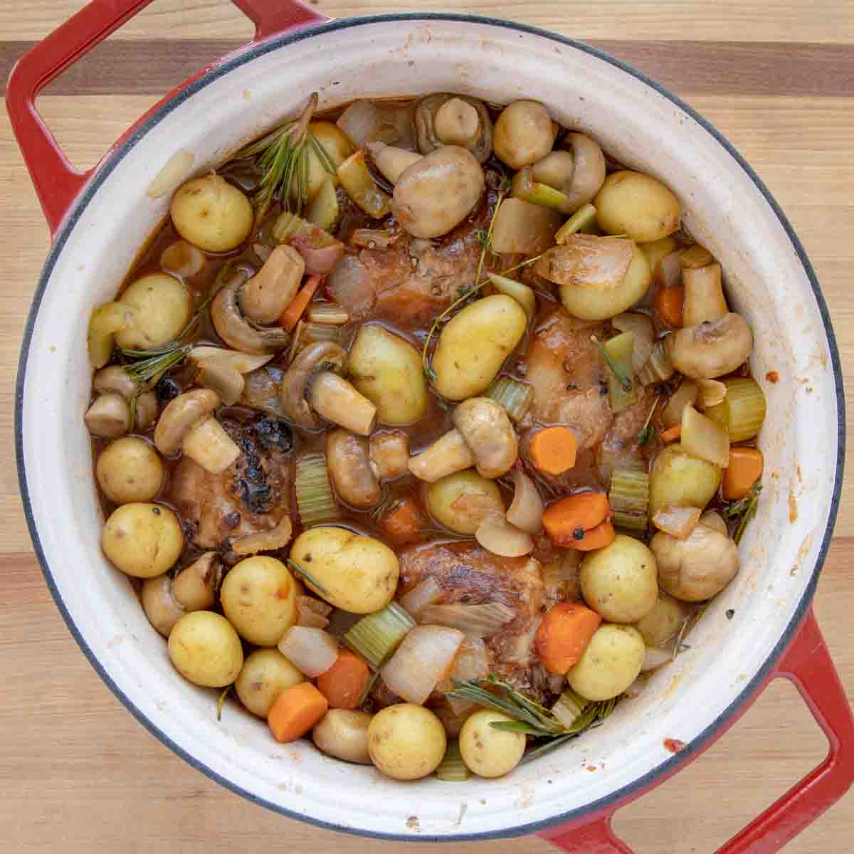 vegetables and stock added on top of the pork shanks in the dutch oven covering them