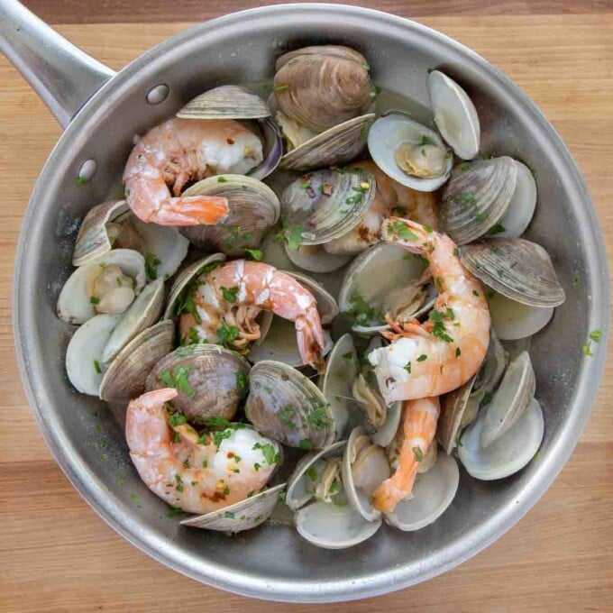 seasoned clams and shrimp in a saute pan