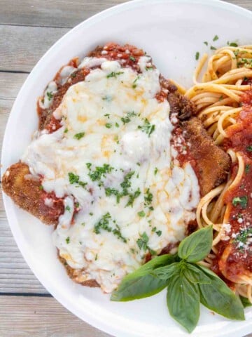 overhead shot of eggplant parm with linguine on a white plate