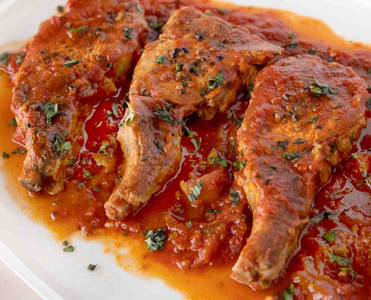 close up of Sicilian pork chops on a white platter