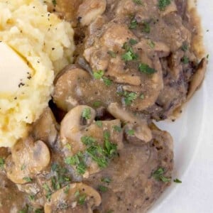 overhead view of salisbury steak with mashed potatoes on a white plate