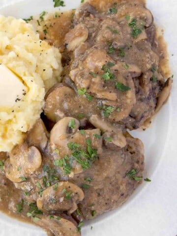 overhead view of salisbury steak with mashed potatoes on a white plate