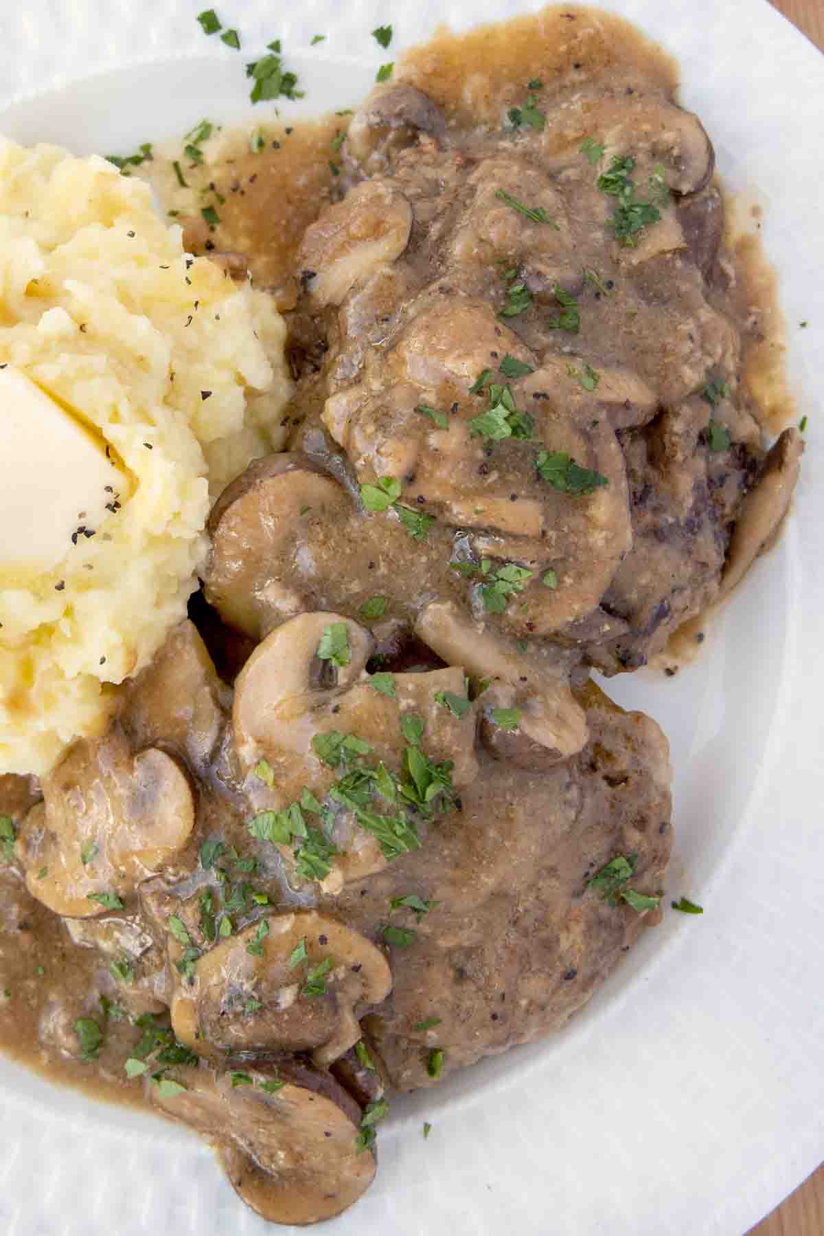 overhead view of salisbury steak with mashed potatoes on a white plate