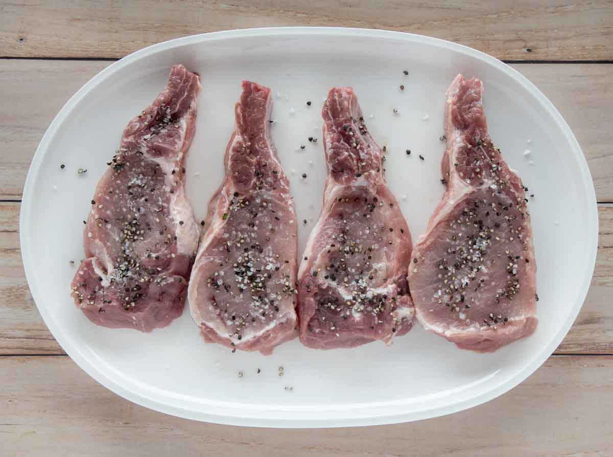 seasoned pork chops on a white platter