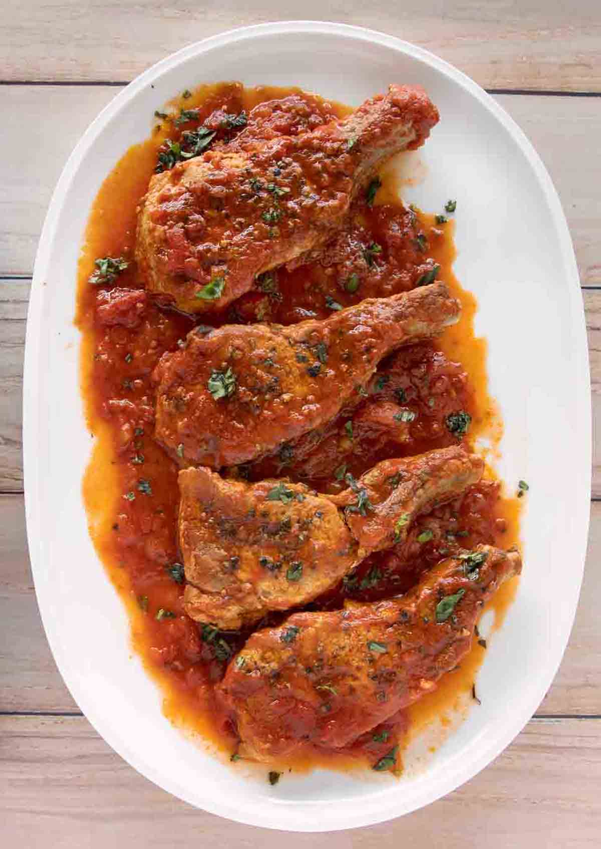 overhead view of 4 Sicilian Pork Chops on a white platter