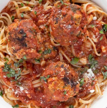overhead view of tuna meatballs and linguine in a white bowl