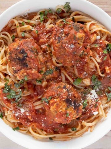 overhead view of tuna meatballs and linguine in a white bowl