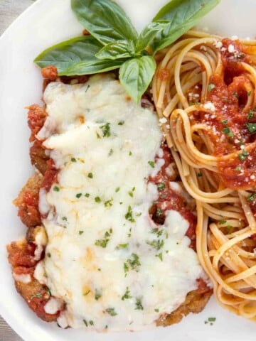 overhead view of veal parm and linguine on a white plate