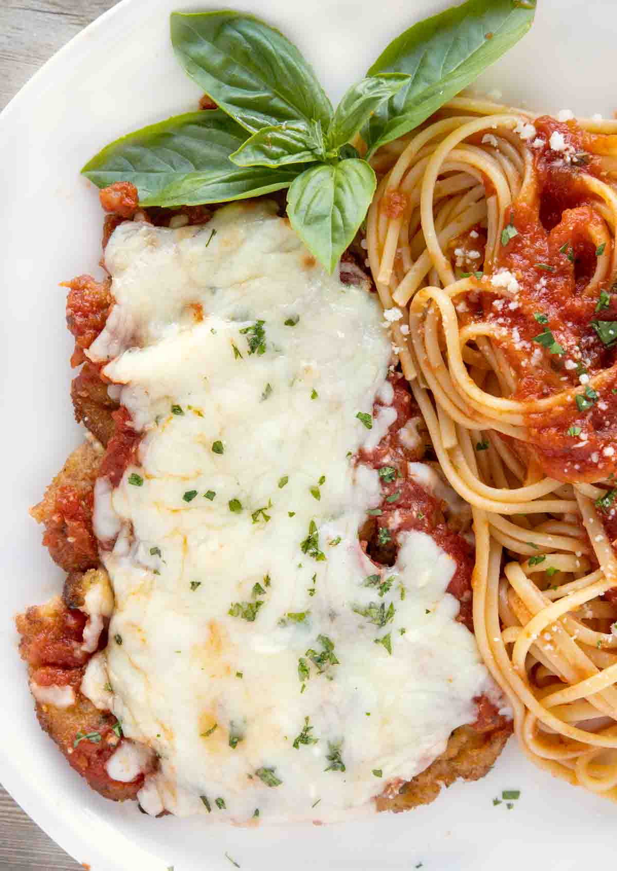 overhead view of veal parm and linguine on a white plate