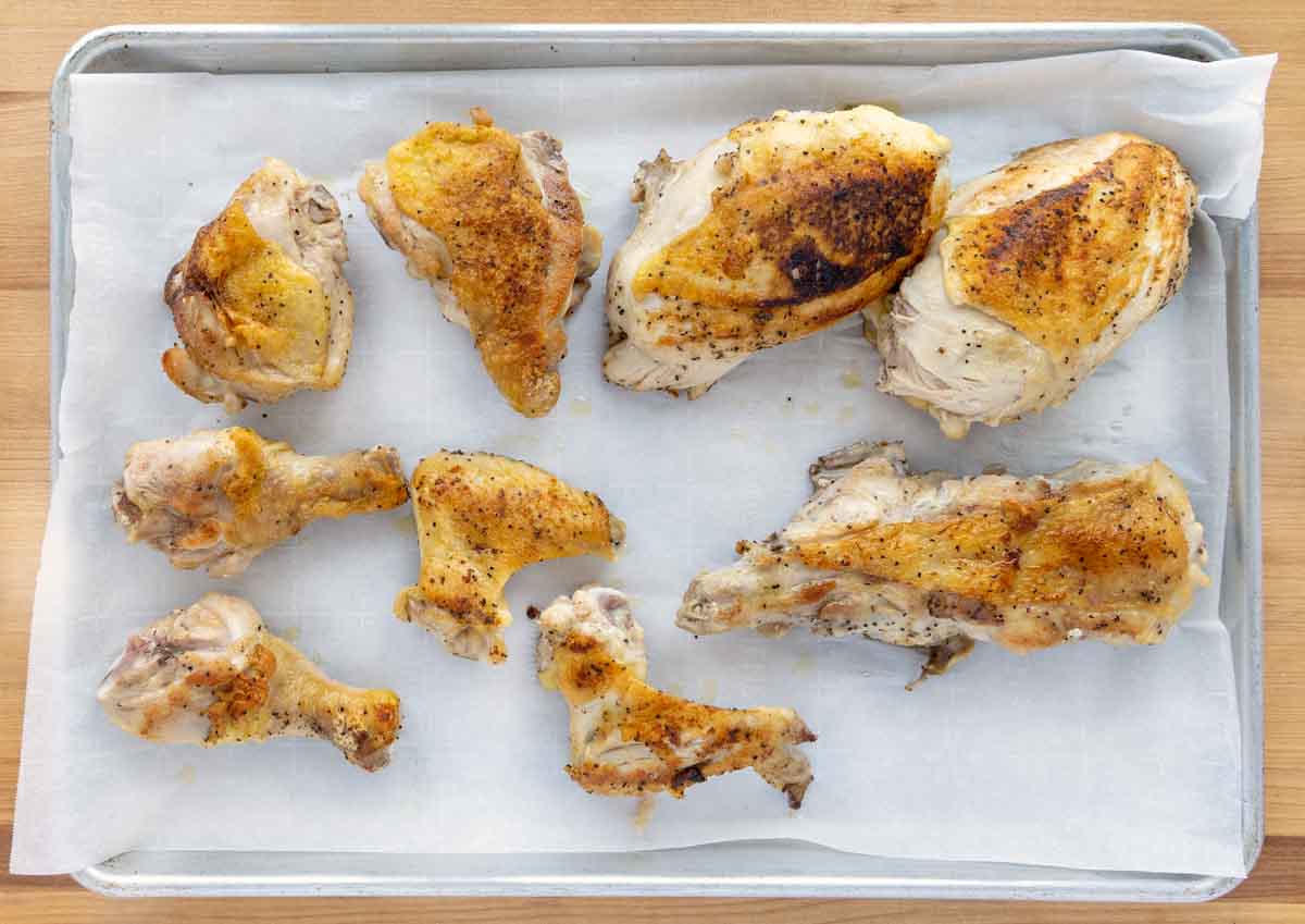 seared chicken pieces on a baking sheet.