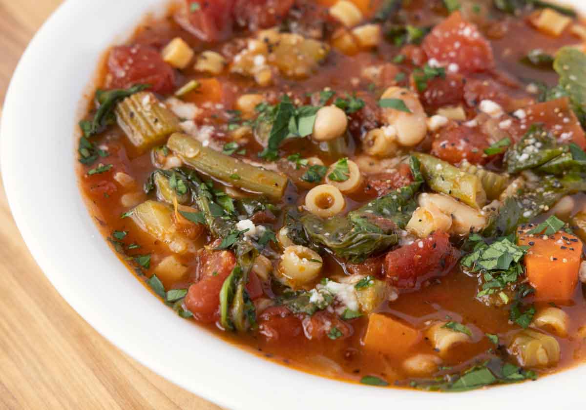 close up view of minestrone in a white bowl