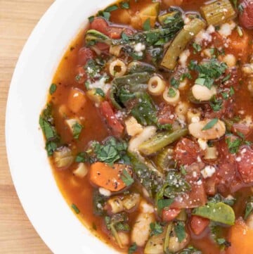 overhead partial shot of minestrone in a white bowl